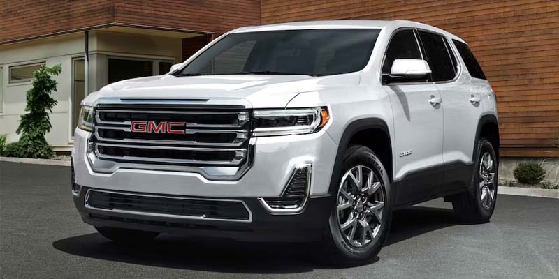 2023 GMC Acadia next to a building