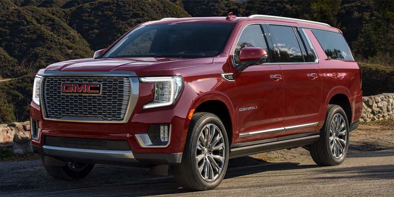 Red 2023 GMC Yukon driving on the road