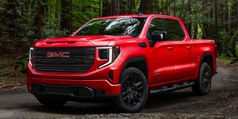 A red 2024 GMC Sierra out by the woods