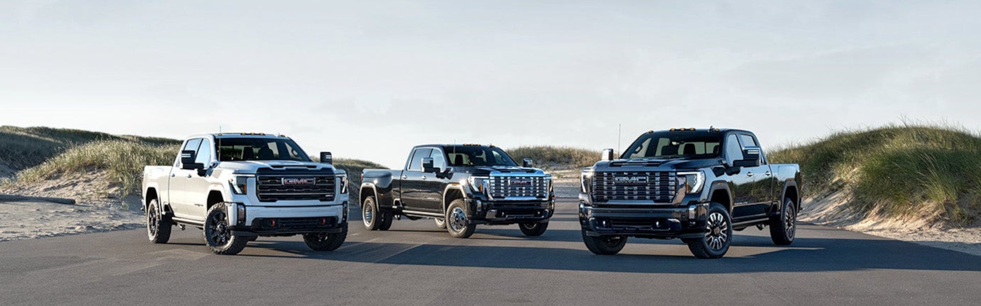 3 2024 GMC Sierra HD Trucks outside on the road