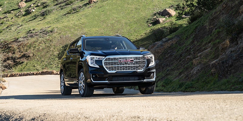 Black GMC terrain driving up hill outside